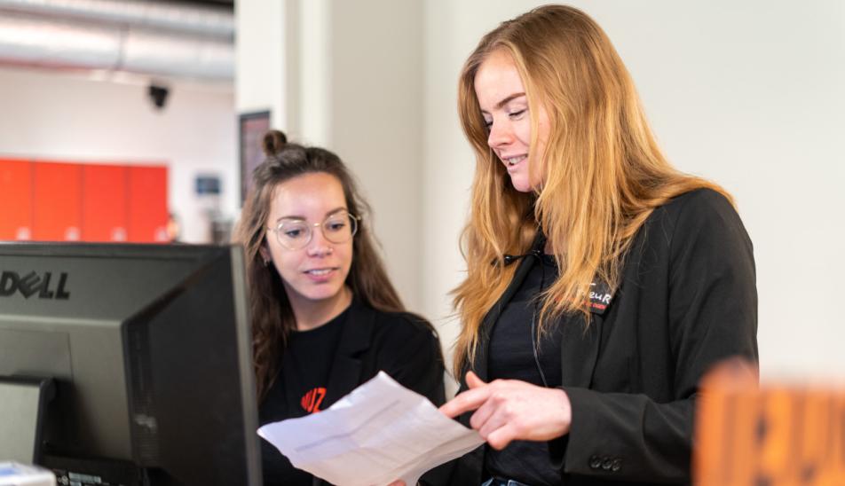 Fleur and Juni working at the reception desk.