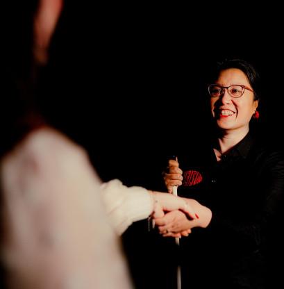 Guide Melly in the Expedition in the Dark. With one hand, she shakes the visitor