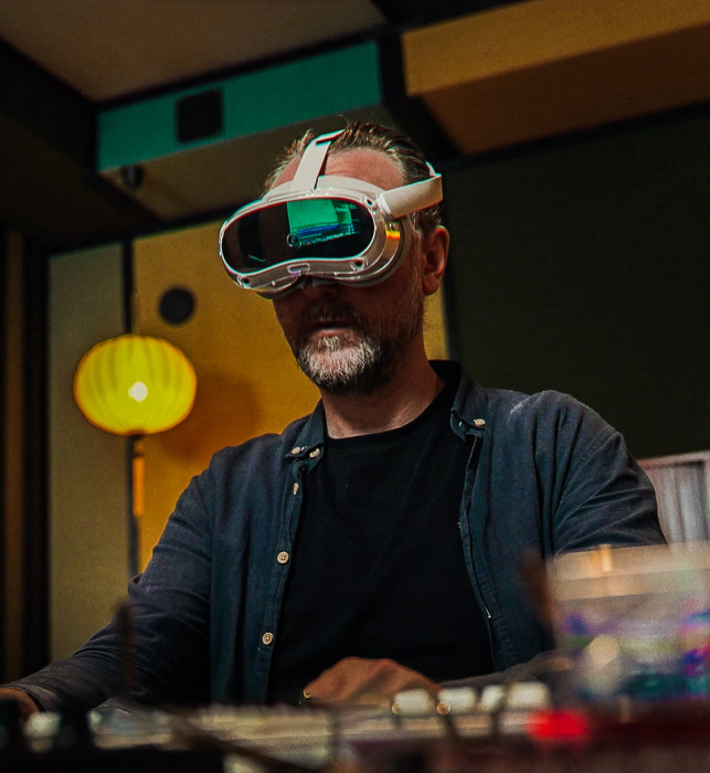 A visitor wearing an AR headset, trying to operate their panel in their own studio. Slightly behind them sits guide Pascal, who is leading the muSEEum on-location experience.
