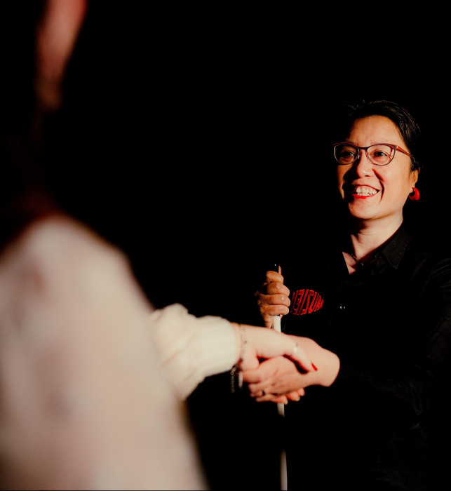 Guide Melly gives the visitor a hand in the Tour in absolute dark.