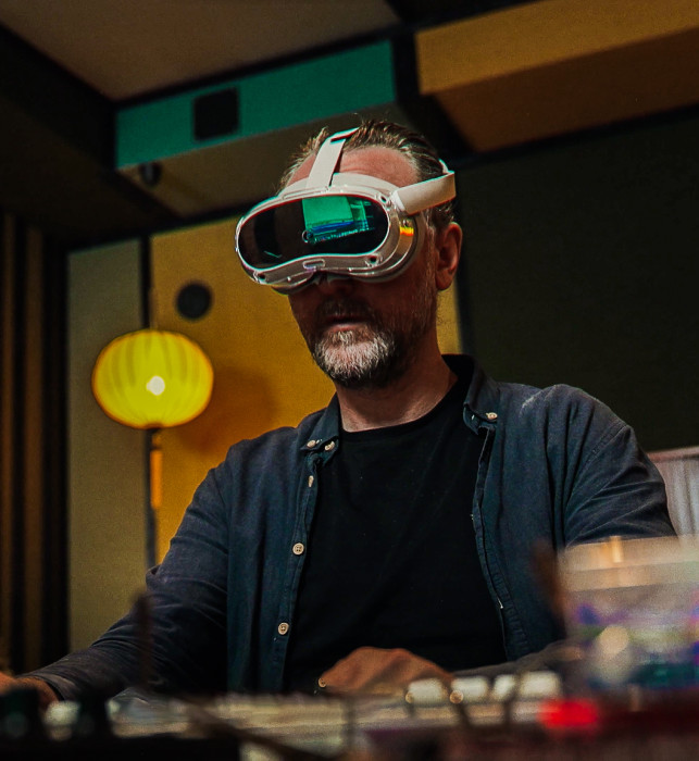 A visitor wearing an AR headset is trying to operate a panel in their own studio. Slightly behind them is guide Pascal, who is leading the muSEEum on-location experience.